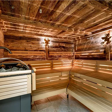 A modern sauna with wooden paneling and soft lighting. The benches provide space for relaxation and recovery.