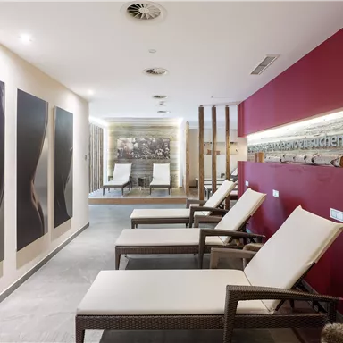 A modern relaxation area with loungers and stylish artworks on the wall. The minimalist decor and warm colors create an inviting atmosphere.
