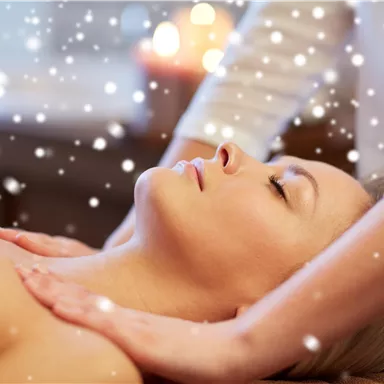 A woman receives a relaxing massage. Gentle snowflakes have a calming effect in the background.