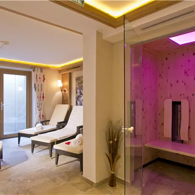 A relaxing wellness area with loungers and a sauna. The atmosphere is calm and pleasant, with soft lighting and modern furnishings.