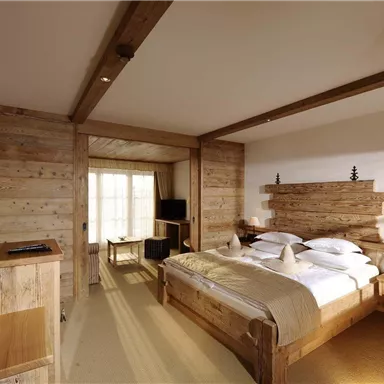 A cozy bedroom with wooden furniture and a large bed. The room is bright and inviting, overlooking a sunny area.