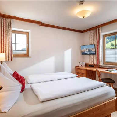 Ein gemütliches Schlafzimmer mit zwei Einzelbetten und natürlichem Licht. Das Zimmer ist einfach und modern eingerichtet, ideal für einen entspannenden Aufenthalt.