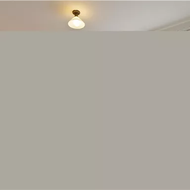 Ein helles Schlafzimmer mit einem Doppelbett und einem gemütlichen Sessel. Große Fenster sorgen für viel Tageslicht.