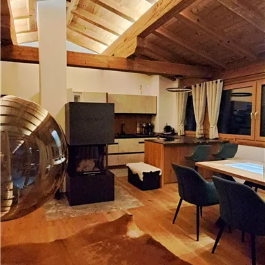 A modern living room with a wooden ceiling and elegant furniture. The room is brightly lit and conveys a cozy atmosphere.