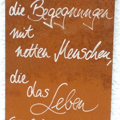 A rusty sign with handwritten text. The quote describes the importance of encounters with nice people in life.