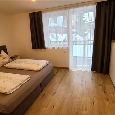 A cozy bedroom with two beds and modern furnishings.
Large windows provide plenty of daylight and a pleasant atmosphere.