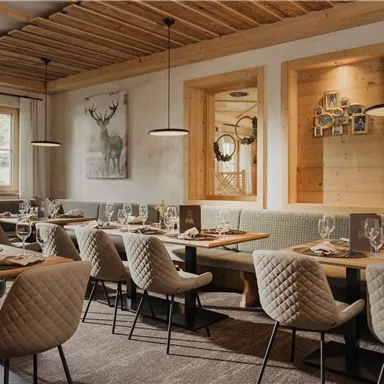 An elegant restaurant with wooden furniture and a cozy atmosphere. The tables are tastefully set and the walls are decorated with artworks.