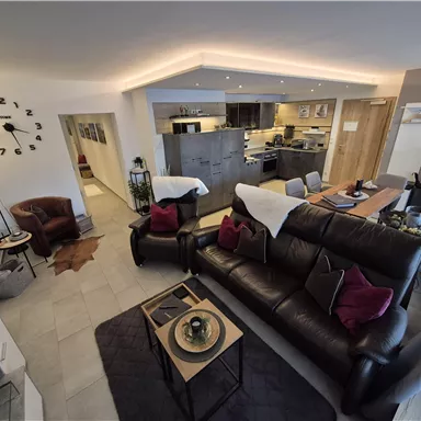A modern living and dining room with elegant furniture. The kitchen is open and offers a cozy atmosphere.