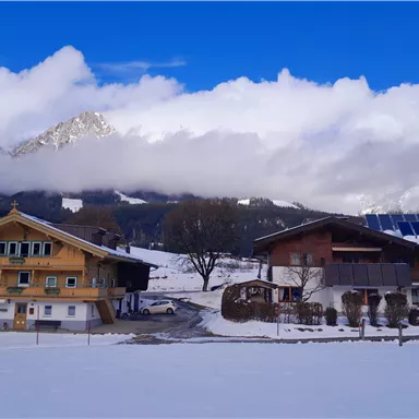 Haus Gaberhel und Haus Widmoser präsentieren sich in winterlich verschneiter Landschaft