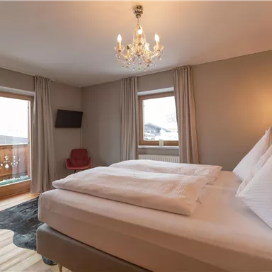 Ein gemütliches Schlafzimmer mit zwei bequemem Betten und modernen Möbeln. Große Fenster lassen viel Licht herein und bieten eine schöne Aussicht.
