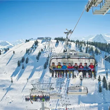 A ski lift ride over snow-covered mountains. The passengers enjoy the view of the winter landscape.