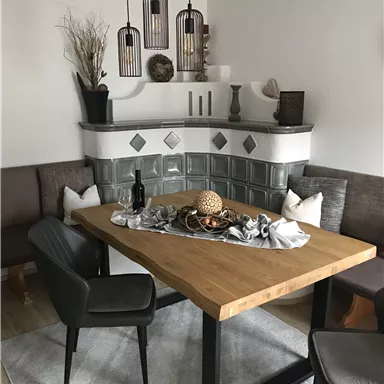 Ein gemütlicher Essbereich mit einem rechteckigen Holztisch und modernen Stühlen. Die Wände sind in neutralen Farben gehalten, und die Beleuchtung wird durch dezente Pendelleuchten akzentuiert.