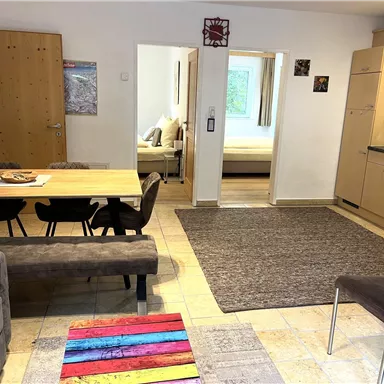A bright living room with a dining table and chairs. The apartment has a modern style and feels inviting.