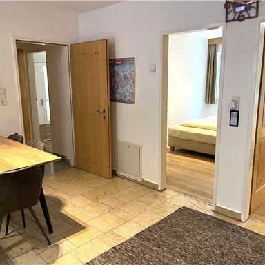 A bright and inviting entrance area with a table and chairs. In the background, doors to other rooms are visible.