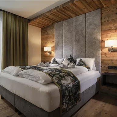 A cozy bedroom with a large bed, modern design, and wooden walls.
Large windows let in plenty of light and create an inviting atmosphere.