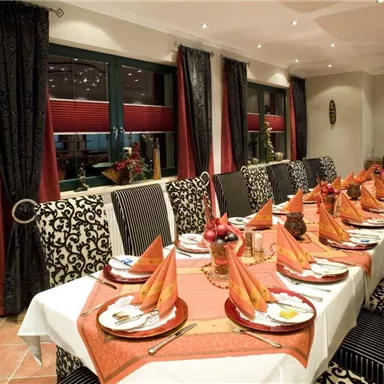 An elegantly set table in a stylish restaurant. The decoration includes orange napkins and an inviting atmosphere.