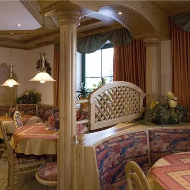 A cozy restaurant with wooden interiors and colorful tablecloths. The decor is simple and inviting.