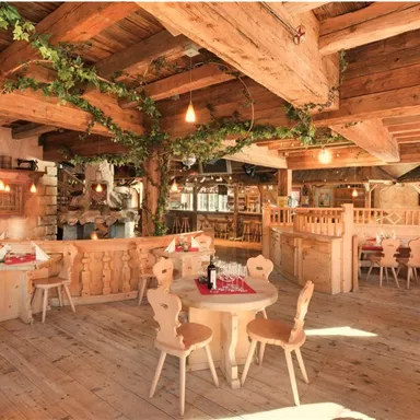 A cozy restaurant with wooden furniture and warm light.
Plants and wooden decorations create an inviting atmosphere.