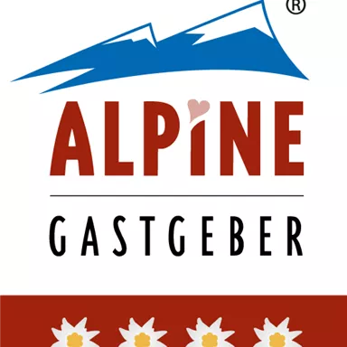 A logo with the inscription "ALPINE GASTGEBER". It features stylized mountains and edelweiss flowers.