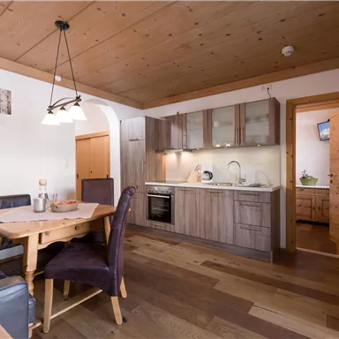 A cozy kitchen with a dining area and modern appliances. The room features wood paneling and bright colors that create an inviting atmosphere.