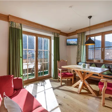 A cozy living space with a dining area and large windows that let in plenty of light. The decor is modern and inviting, with a beautiful view of the mountains.