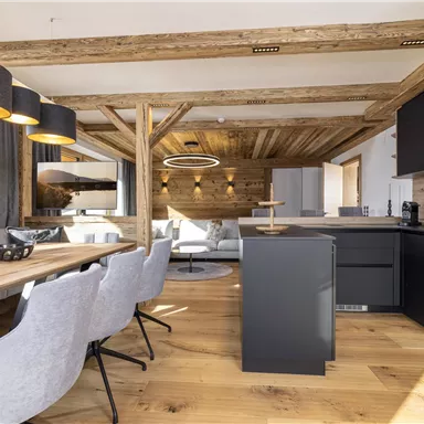 A modern kitchen with a wooden dining area. The space is bright and inviting, with elegant furniture and natural materials.