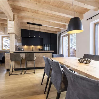 A modern designed kitchen with a wooden ceiling and elegant furniture. The room is bright and invites you to linger.