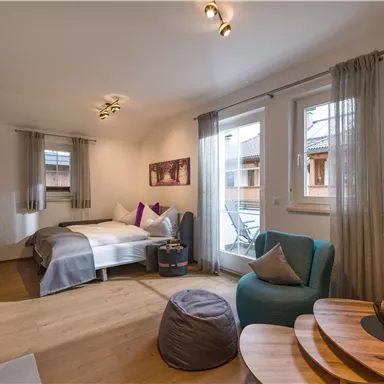A cozy room with a double bed and seating space. Large windows provide plenty of daylight and a pleasant atmosphere.