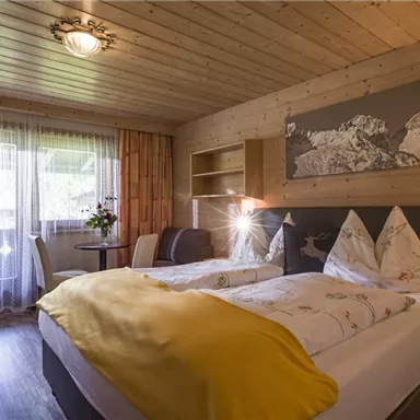 A cozy room with wooden paneling and two beds.
Windows with a view of nature and a relaxing atmosphere.