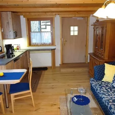 A cozy vacation apartment with a modern kitchen and an inviting living area. The space is brightly lit and offers a comfortable atmosphere.