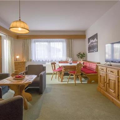 A cozy living room with modern furniture and a large window. The room is bright and inviting, perfect for relaxing.