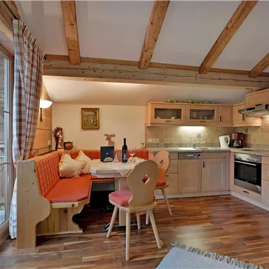 A cozy kitchen with wooden decor and a dining area. The space is bright and inviting, ideal for sociable meals.
