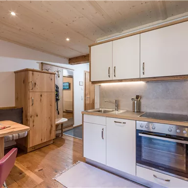 Eine moderne Küche mit Holzoberflächen und ausreichend Platz zum Kochen. Der Essbereich hat einen Tisch und Stühle in einem gemütlichen Ambiente.