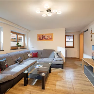 A cozy living space with a large gray couch and a television.
Large windows let in plenty of light and create an inviting atmosphere.