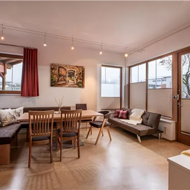 A modern living room with a wooden animal table and comfortable seating. Large windows let in plenty of light and create an inviting atmosphere.