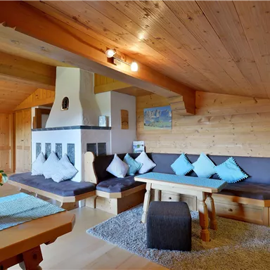 A cozy living space with wood paneling, a fireplace, and comfortable seating. The room is bright and inviting, perfect for relaxing.