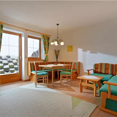 A cozy living room with colorful furniture and a dining table.
Large windows provide plenty of natural light and an inviting atmosphere.