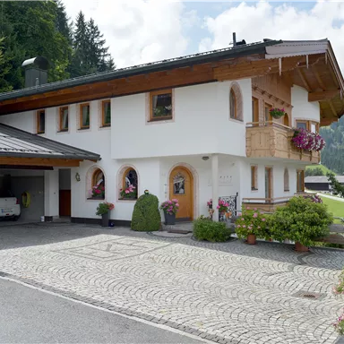A charming house in alpine style with a green outdoor area. Surrounded by trees and a picturesque landscape.