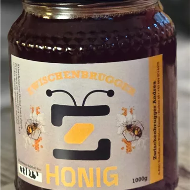 A jar of honey with an attractive label. The label features bees and the inscription "Zwischenbrugger Honey".