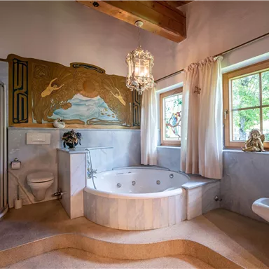 Ein elegantes Badezimmer mit einerBadewanne und einer separaten Dusche. Große Fenster lassen viel Licht herein und sorgen für eine entspannte Atmosphäre.