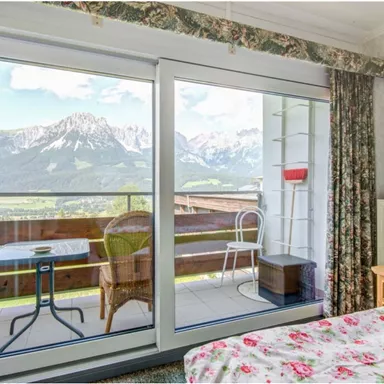 Ein gemütliches Zimmer mit Blick auf die Berge. Große Fenster bieten einen herrlichen Ausblick auf die Landschaft.