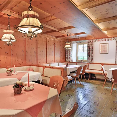 A cozy restaurant with wooden paneling and warm lighting. The tables are neatly set and invite you to linger.