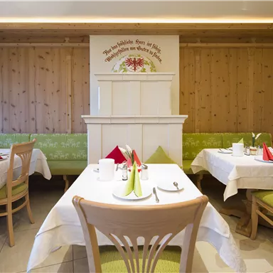 An inviting restaurant with wooden walls and bright tables. The tables are festively decorated with colorful napkins.
