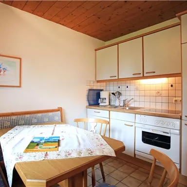 A bright kitchen with a dining area and modern appliances. The room is cozily decorated and invites you to linger.