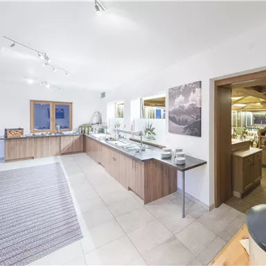 A modern interior design with wood and stone surfaces. The space is bright and welcoming, ideal for an exhibition or presentation.