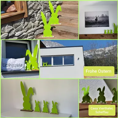 A friendly Easter decoration with green rabbit figures and a "Happy Easter" sign. The image shows various views of a modern house with a mountain view.