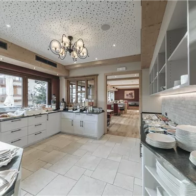 An elegant dining room with a buffet and a cozy atmosphere. Bright walls and windows provide plenty of light.