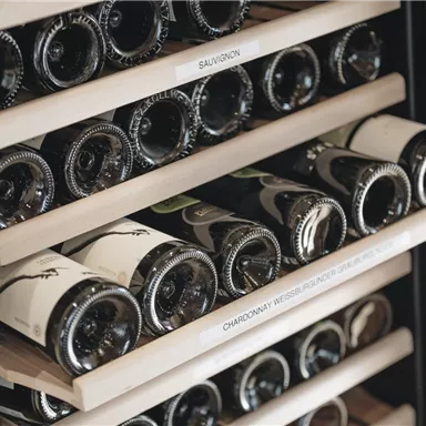 A wine storage with several shelves full of wine bottles. The bottles are sorted and labeled.