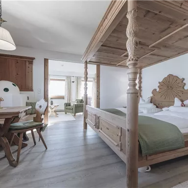 A cozy room with a wooden children's bed and a dining table. The space is bright and friendly with modern furnishings.