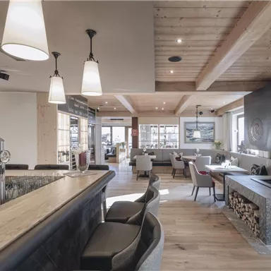 A modern restaurant with an inviting ambiance. Wooden ceilings and stylish furniture create a cozy atmosphere.